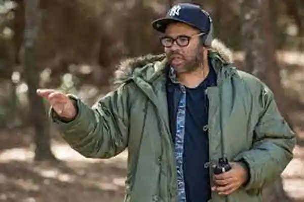 Jordan Peele giving direction on set, clapperboard in frame